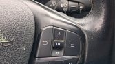 Steering wheel control cluster with OK in the center, directional arrows, and adjacent phone and menu buttons.