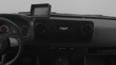 Left-hand drive car cockpit with steering wheel, instrument cluster, central radio and climate controls, and a GPS/navigation device mounted on the dashboard (black-and-white photo).