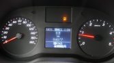 Car dashboard with speedometer on left (0–180 km/h) and tachometer on right; center screen shows 8.8 km trip, odometer 94,877 km, gear in P, ASC OFF warning lit above; time 11:59, temp 18.5°C.