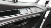 Interior car door panel with window/lock controls and a chrome door handle.