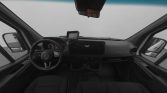 Front interior of a dark van cabin, view of steering wheel, dashboard, and GPS screen.