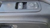 Driver's door panel showing two power window switches, a four-way mirror adjustment pad, and a window/mirror lock button