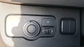 Car interior headlight control panel: rotary light switch with Auto setting, adjacent fog light button, and a small dimmer switch to adjust dashboard lights.