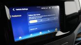 Car touchscreen showing Vehicle Settings with Preference highlighted, including Follow Me Home timing and Vehicle Lock options on a blue UI panel.
