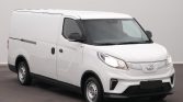 Front-left view of a white commercial cargo van with black grille and headlights, parked indoors with no branding visible to communicate its purpose as a delivery vehicle.