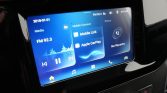 Car infotainment touchscreen showing media, apps, and phone options on a blue UI (FM radio, Mobile Link, Apple CarPlay).