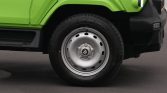 Close-up of a lime-green vehicle front wheel with a silver steel rim and black tire.