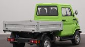 Bright green compact pickup truck seen from the rear-left, with a metal flatbed and small cabin.