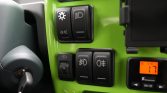 Green car dashboard controls with headlight and fog light switches; ignition key on the left and a small orange display showing 17°C.