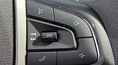 Close-up of car steering wheel audio/phone control panel showing SRC switch, volume up/down, mute, and call buttons in a glossy black housing