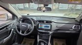 Interior of a modern SUV cockpit: steering wheel, digital instrument cluster, and center touchscreen with blue car graphic in view