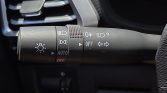 Stalk on steering column showing headlight controls, AUTO mode, fog lights, and turn signals.