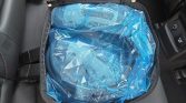 Blue plastic-wrapped package inside a black zippered case laid on a car seat.