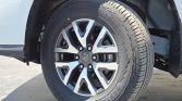 Close-up of a car's aluminum alloy wheel with a black tire, showing the tread and wheel well.