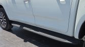 White pickup truck shown from the side with black running boards beneath the doors and a visible wheel on the left.