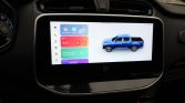Infotainment touchscreen displaying app icons on the left and a blue pickup truck graphic on the right in a car cabin panel.