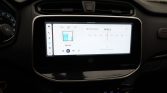 Touchscreen infotainment system in a car showing FM radio (FM 92.6) with left-side icons and channel list, above the climate controls and center dash trim.