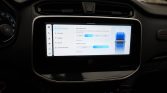 Car dashboard touchscreen showing Vehicle Settings with a blue car illustration on the right side.