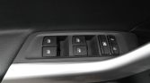 Car interior door panel: row of power window switches with a silver door handle visible below.