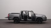Gray four-door pickup truck with all doors open, exposing the cabin and seats in a studio setting.