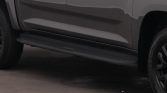 Side view of a gray pickup truck showing the bottom running boards along the door.