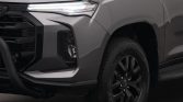 Front-left corner of a gray pickup truck, featuring an LED daytime running light, bold grille, and front bumper.