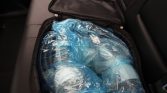 Open bag or case filled with blue gel ice packs wrapped in clear plastic, packed for cooling or transport value storage.
