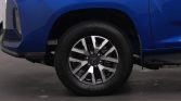Blue vehicle's front wheel with silver alloy rim and tire visible, side fender close-up.