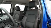 Interior view of a car with black leather seats and red contrast stitching, driver seat and center console visible, blue exterior door frame on the right