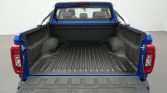 Blue pickup truck with cargo bed visible, tailgate down in a showroom setting: empty bed ready for loading.