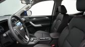 Inside a modern SUV: black leather seats with red stitching, steering wheel, center console, and touchscreen infotainment.