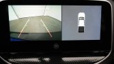 Rearview camera and top-down car view: left shows parking guidance lines (yellow) with red ends; right shows a 360° bird's-eye view of the vehicle in a space.
