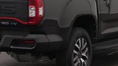 Rear left side of a dark gray pickup truck, showing the taillight, bumper, and wheel.