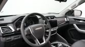 Interior of a modern car cabin focused on the steering wheel with Maxus logo, center console rotary gear selector, and large touchscreen display.