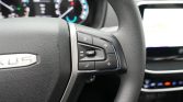 Steering wheel controls on the right side, including volume, mute, phone, and media buttons inside a car dashboard.