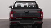 Rear view of a black Maxus T90 EV pickup with red accents, showing taillights and embossed MAXUS badge on the tailgate.