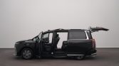 Black minivan in a studio with all doors open and the rear hatch raised, exposing the interior seating area.