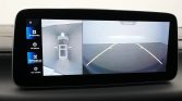 In-car display showing 360-degree top-down view of car in a garage and rear parking camera withGuidance lines on the right panel.