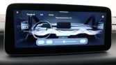 Infotainment climate control screen in a car showing dual-zone temperatures around 21°C and airflow visualization across the dashboard.
