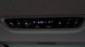 Car climate control panel with blue-lit icons showing 21°C, Auto mode, and fan settings.