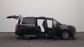 Black minivan with all doors open, showing a spacious interior and extended rear hatch/vacuum tailgate area.