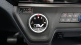 Circular gear selector labeled R N D with EV logo, in a car dashboard next to climate control buttons