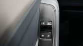 Driver-side car door panel with four window control buttons and lock switches for door and windows