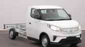 Three-quarter front view of a white cab-forward utility truck with an exposed rear chassis for a cargo bed attachment.