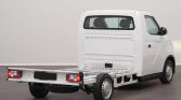 Rear and side view of a white compact van with an exposed metal flatbed chassis, awaiting customization.