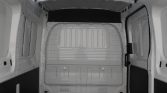 Empty white van cargo area with metal walls, ribbed rear panel, and black rubber floor mat in a blank loading space.