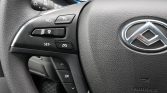 Close-up of a car steering wheel left-side controls featuring cruise control buttons and an OK/Menu pad.