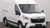 Front-left view of a white cargo van with a tall roof in a studio setting, showing its large black grille and headlights.