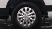 Close-up of a car wheel with a silver multi-spoke hubcap and Honda emblem, mounted on a black tire under a white vehicle body.