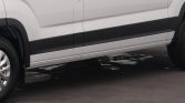 Side view of a white cargo van with black lower body molding and visible wheel.